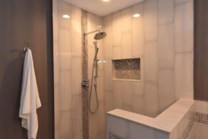 Beautifully tiled master bathroom shower with Delta plumbing fixtures