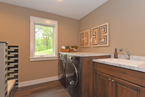 Laundry room with white trim and wood stain cherry cabinets