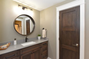 Basement bathroom with white trim and dark stain doors and cabinets